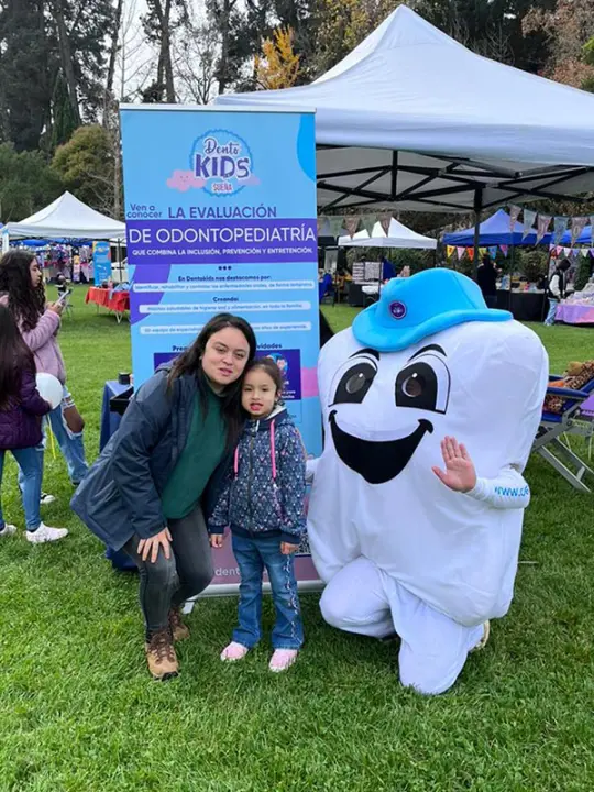 Familia con la mascota de Dentosalud en una actividad de convenio
